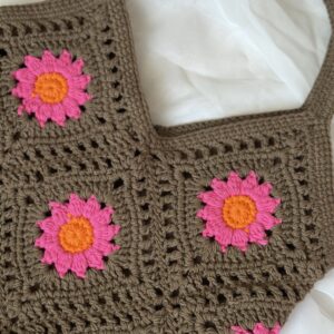 Szydełkowa torebka damska na ramię, kolory to brąz, jaskrawy róż i pomarańcz. torba ma bawełnianą podszewkę z kieszonką.