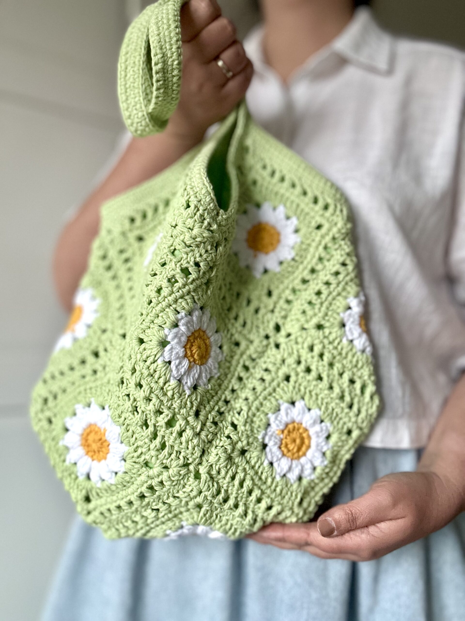 ręcznie wykonana szydełkowa torebka na ramię idealna na wiosnę i lato. modny kolor pistacjowy a na jego tle stokrotki. bawełniana podszewka z kieszonką