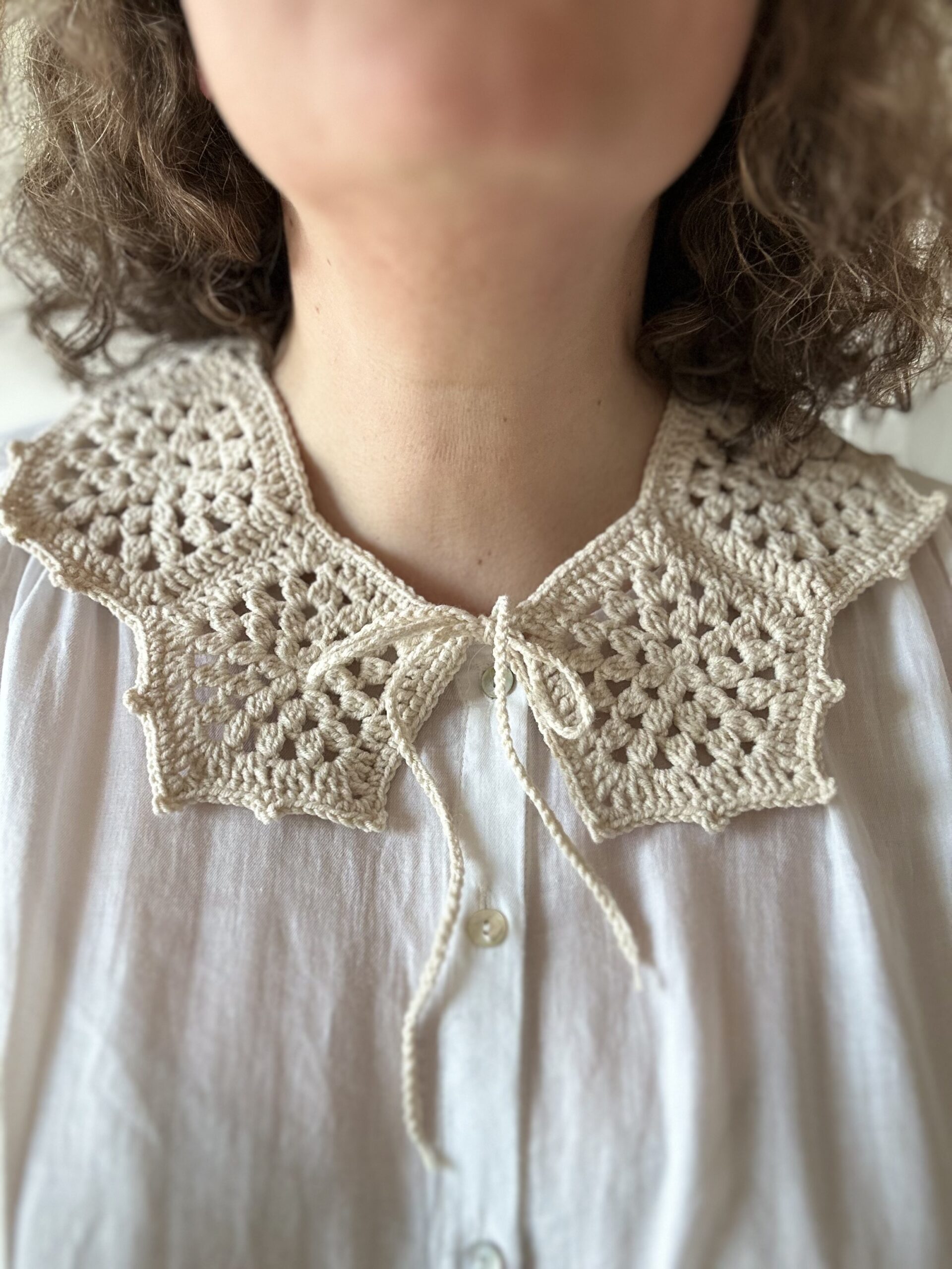 Ażurowy kołnierzyk wykonany na szydełku w kolorze ecru.