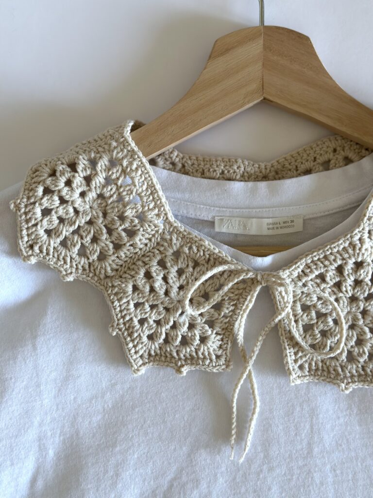 beżowy kołnierzyk zrobiony na szydełku. wiązany z przodu na troczki,