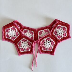 kołnierzyk dziergany na szydełku. ażurowy, wiązany na troczki, raczej w stylu casual, nie elegancki. w odcieniach czerwieni, różu i bieli