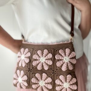 Szydełkowa torebka w retro kwiaty. kolory to czekoladowy brąz i pudrowy róż z dodatkiem jasnego beżu. Torebka ma regulowany pasek ze skóry naturalnej, co pozwala nosić ją na dwa sposoby - na ramieniu lub przez głowę. torba ma bawełnianą podszewkę i jest zapinana na zamek błyskawiczny. Po odpięciu paska torebkę można prać w pralce.