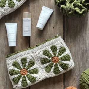 szydełkowa kosmetyczka na kobiece drobiazgi. wykonana na szydełku, ale z bawełnianą podszewką i zapinana na zamek błyskawiczny. w kolorach oliwkowym, ecru i miedzianym.