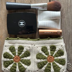 kosmetyczka handmade, dziergany organizer do torebki z bawełnianą podszewką, zapinany na zamek. styl boho. kolor główny to ecru, kwiaty w kolorach rdzawo oliwkowych.