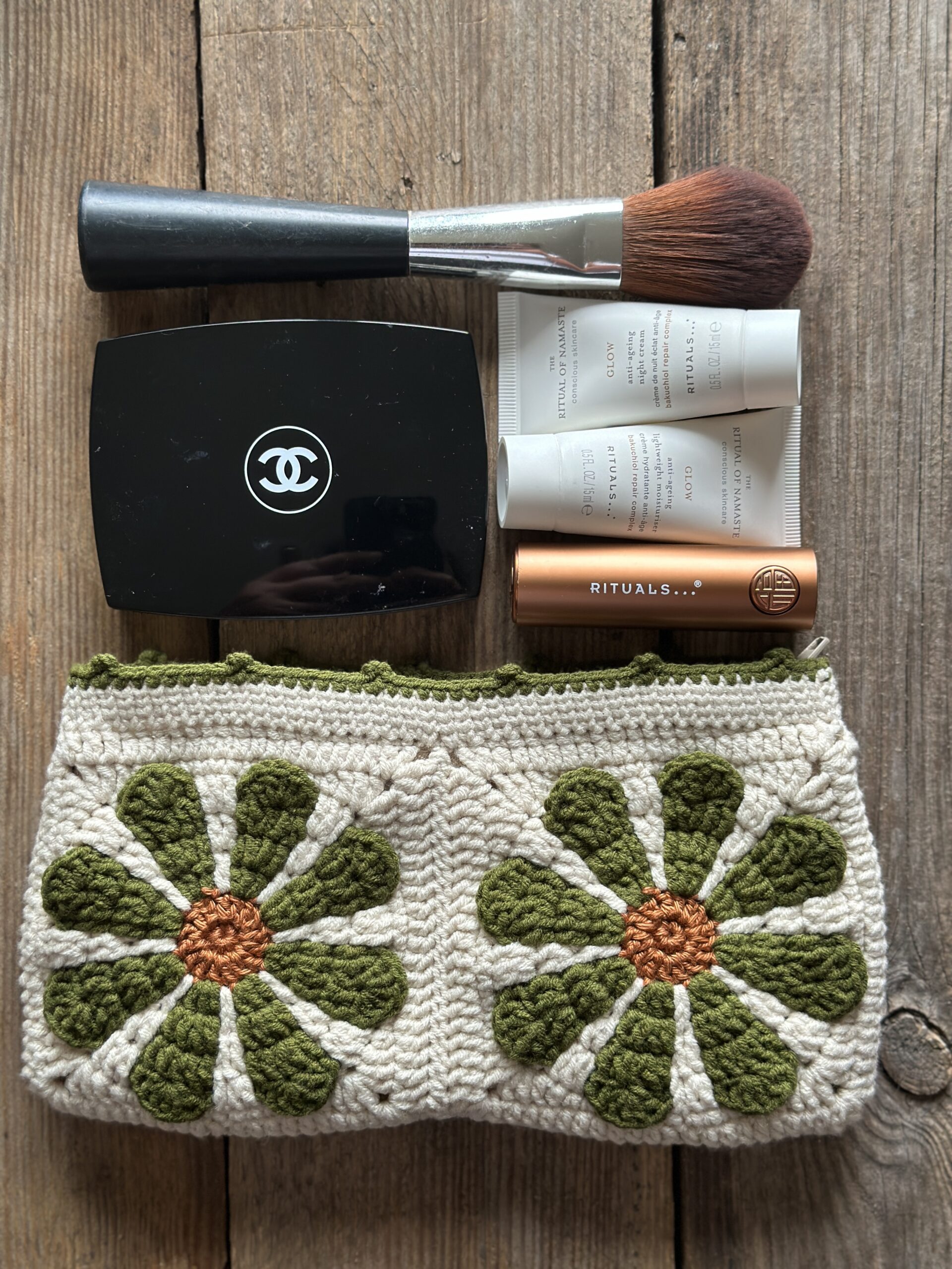 kosmetyczka handmade, dziergany organizer do torebki z bawełnianą podszewką, zapinany na zamek. styl boho. kolor główny to ecru, kwiaty w kolorach rdzawo oliwkowych.