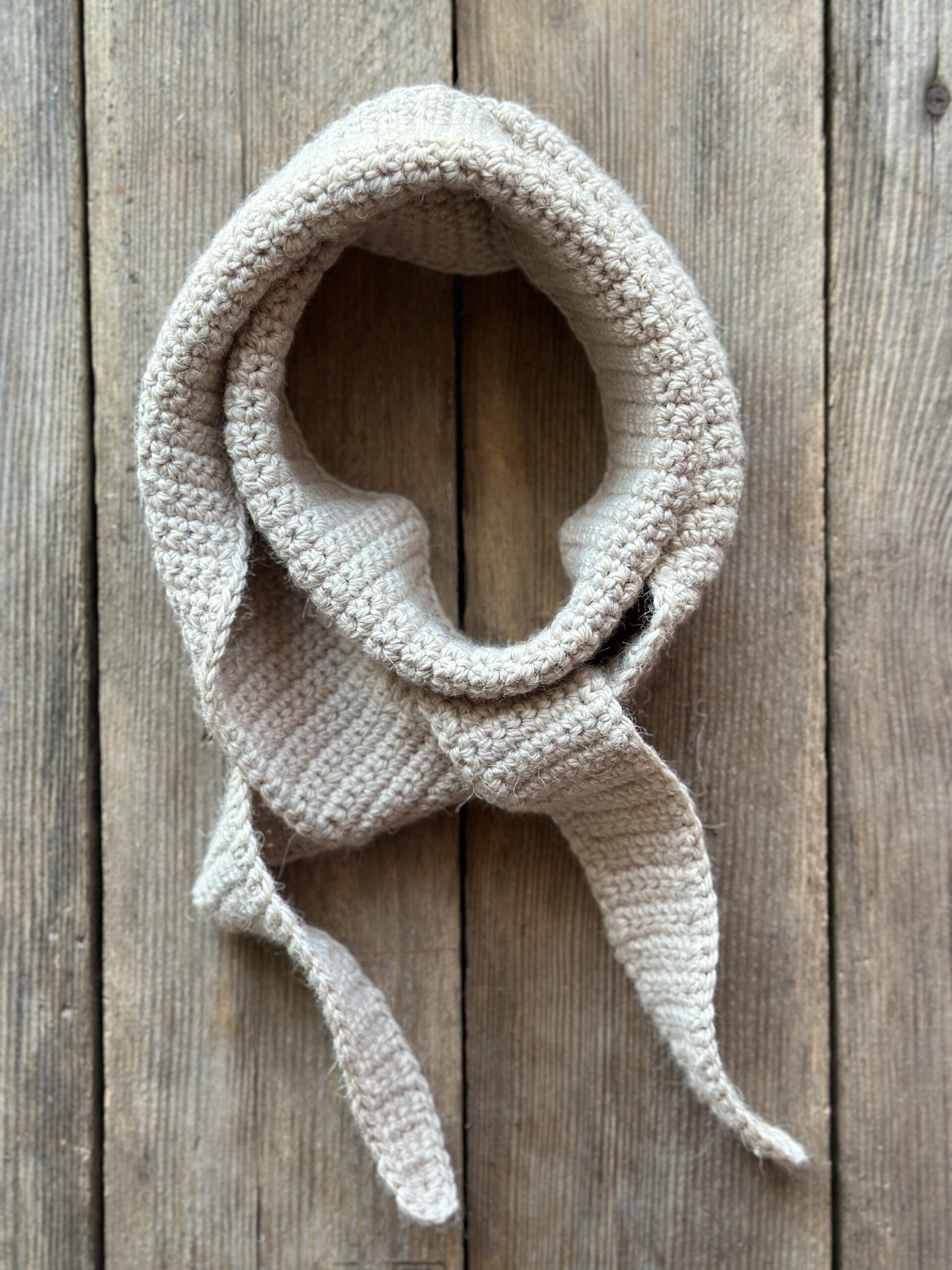 szalik długi ale wąski, dziergany na szydełku. wykonany z przędzy, która jest mieszanką wełny i alpaki. nie gryzie i nie drapie. kolor to jasny, ciepły beż. Szalik można wiązać na kilka sposobów, jego długość to około 1,5 metra.