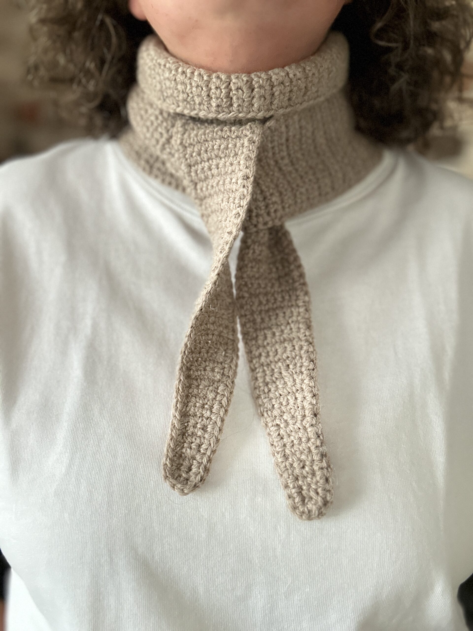 szydełkowy mini szalik. długi na półtora metra, ale wąski, zwężany na końcach. wykonany z włóczki będącej mieszanką wełny i alpaki. nie gryzie, nie drapie. kolor beżowy. idealny do jesiennych i zimowych stylizacji. możliwość wiązania na kilka sposobów. bardzo ciepły.