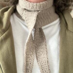 szydełkowy mini szalik. długi na półtora metra, ale wąski, zwężany na końcach. wykonany z włóczki będącej mieszanką wełny i alpaki. nie gryzie, nie drapie. kolor beżowy. idealny do jesiennych i zimowych stylizacji. możliwość wiązania na kilka sposobów. bardzo ciepły.