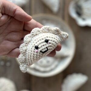 szydełkowy brelok pieróg ręcznie robiony. wykonany z miękkiej włóczki z dołączonym kółkiem i karabińczykiem. ma wyszyty uśmiech i bezpiecznie oczka. unikalny dodatek do plecaka, torebki, kluczy.