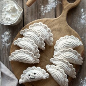 szydełkowy brelok pieróg ręcznie robiony. wykonany z miękkiej włóczki z dołączonym kółkiem i karabińczykiem. ma wyszyty uśmiech i bezpiecznie oczka. unikalny dodatek do plecaka, torebki, kluczy.