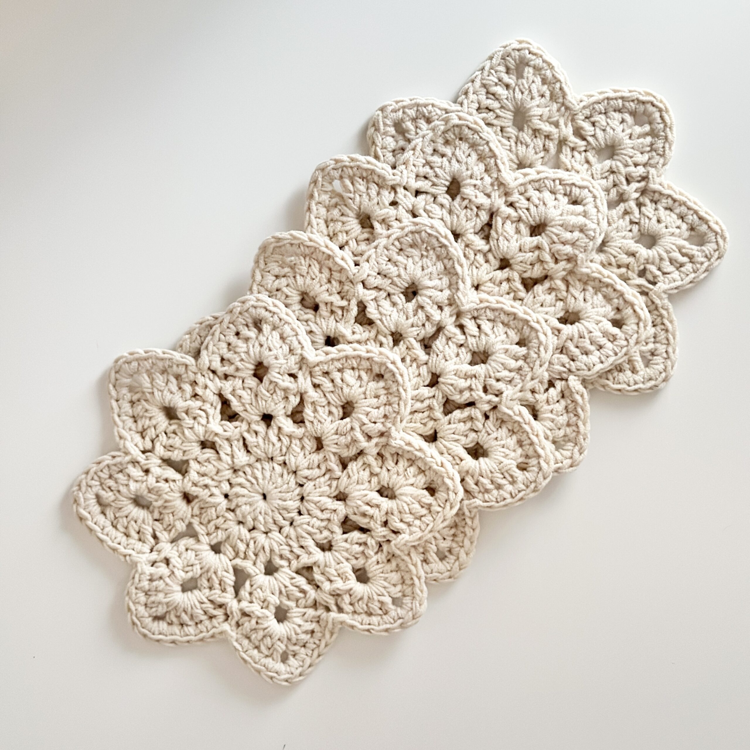Zestaw podkładek pod kubki wykonanych ręcznie na szydełku, maja kwiatowy design, odcień jasny beż.